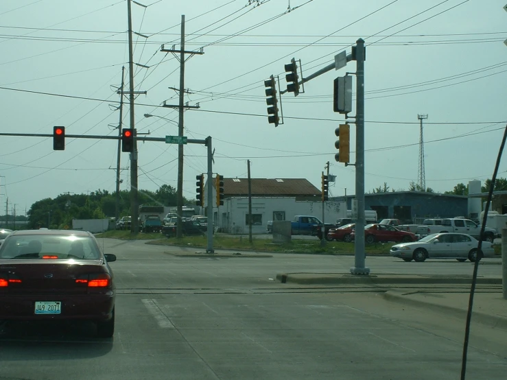 cars driving on an empty street with power lines overhead