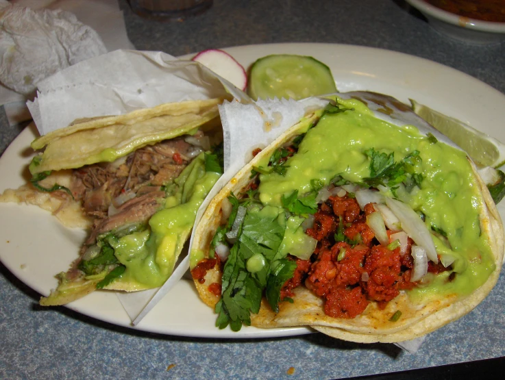 two food entrees with a salad on top are on a white plate