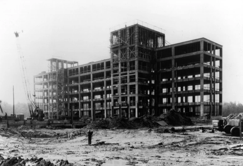 a very large building in a city with lots of construction equipment on it