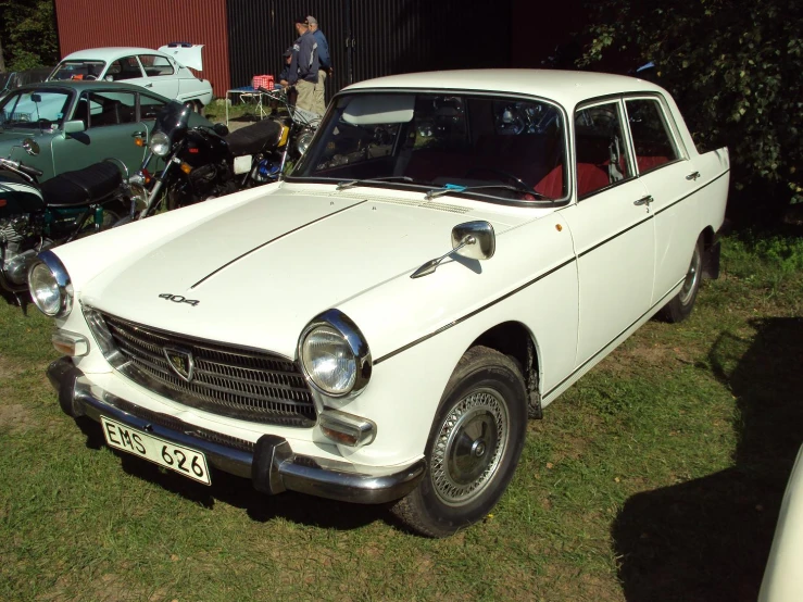 a white car is parked in the grass