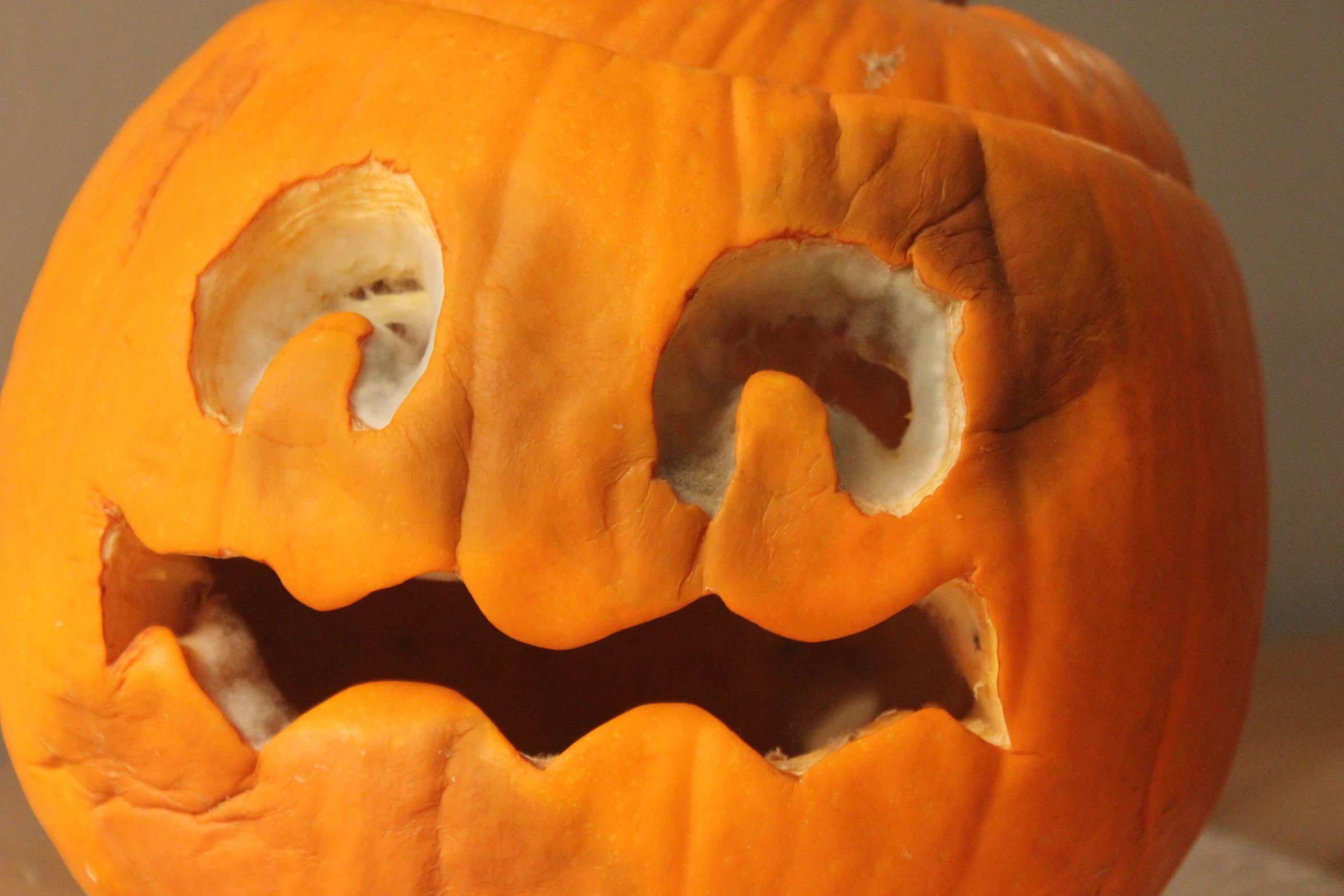 an orange pumpkin with its mouth open on a table