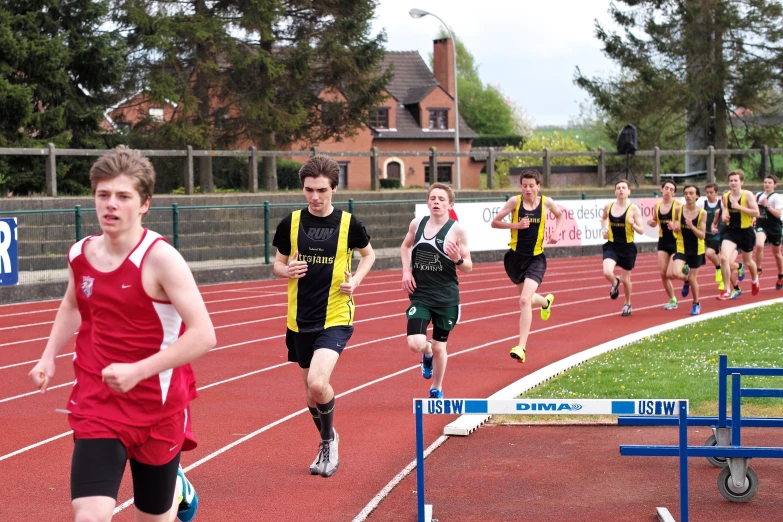 a group of young men on a track running on a track
