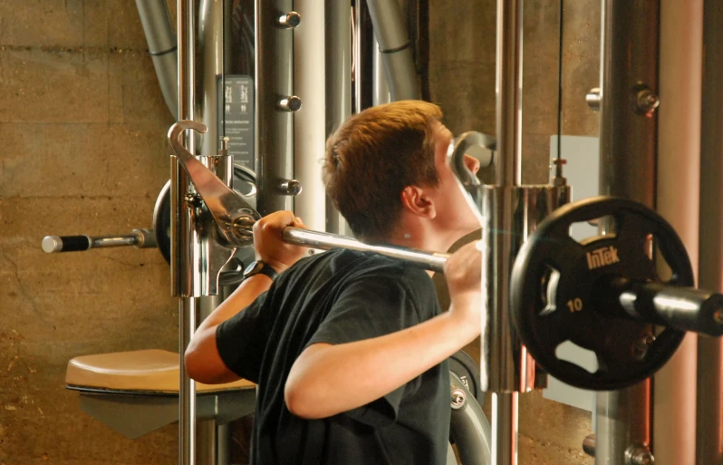 a man using a barbell machine to do a squat