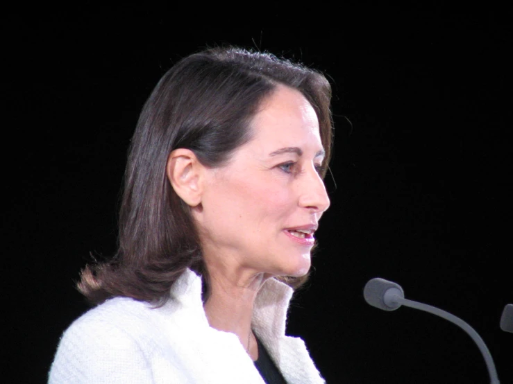 a woman with dark hair in front of a microphone