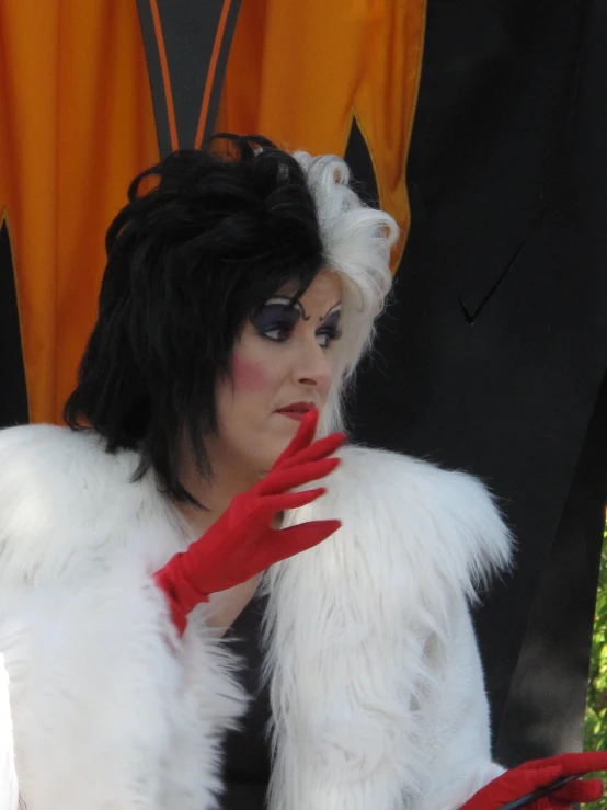 a woman in furs posing next to some red gloves