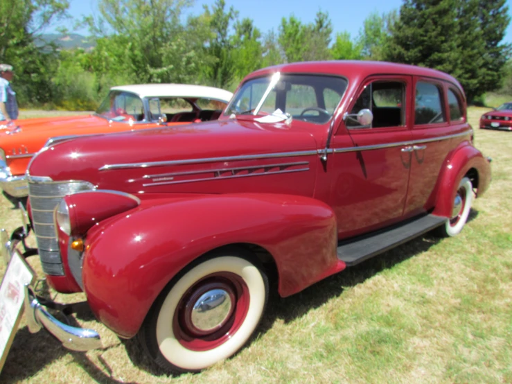 a vintage red car on display at a car show