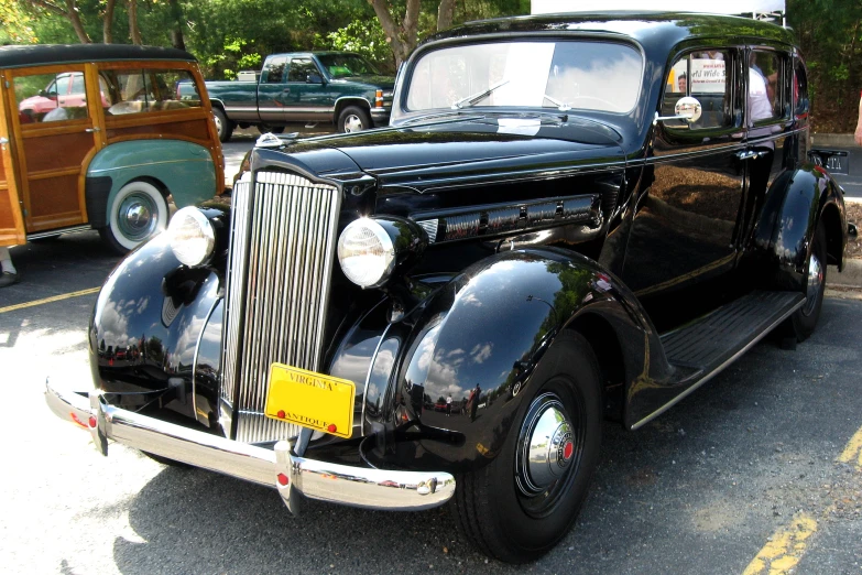 an old black car is parked in a lot