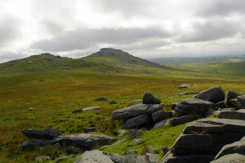 large rocks are on a grassy hillside