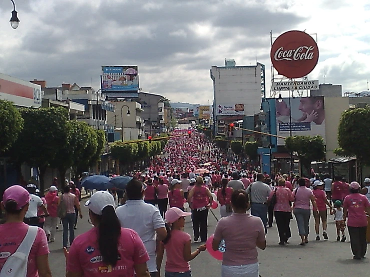 a street crowded with people dressed in pink