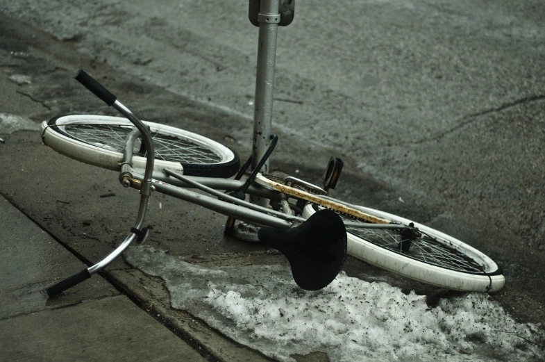 a broken bike lies on the street after it was hit