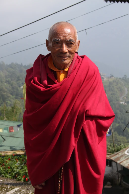 a monk in red poses for the camera