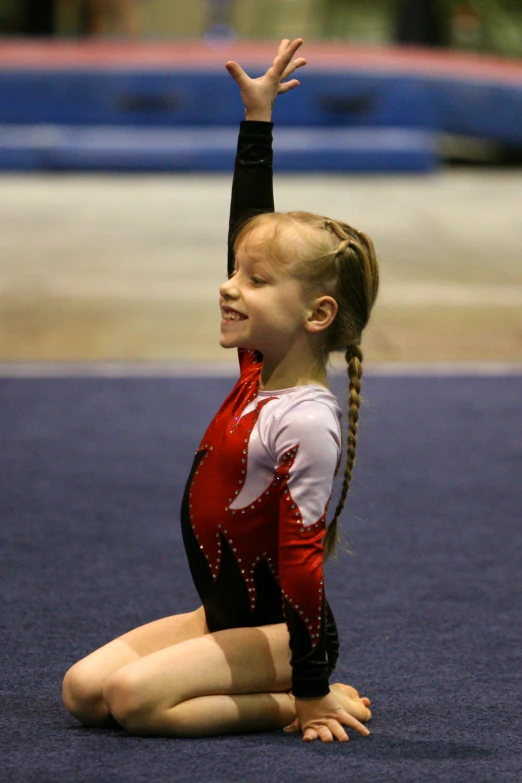 a little girl sitting on the floor doing soing