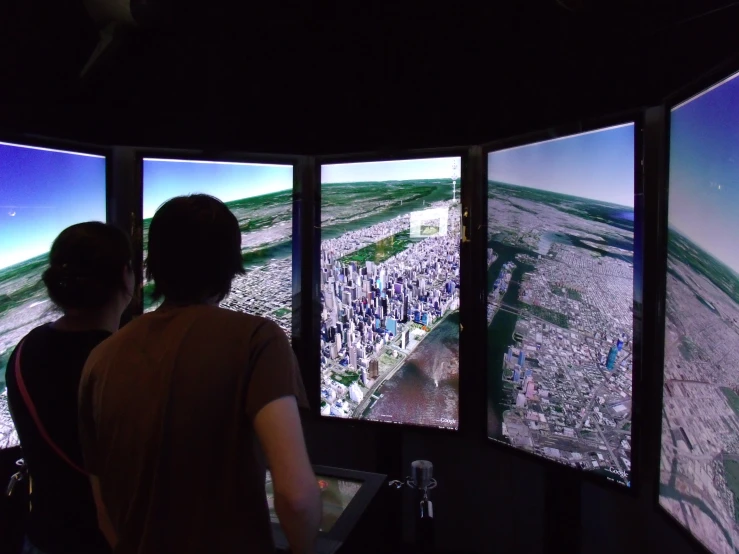 two people look at large screens on a wall