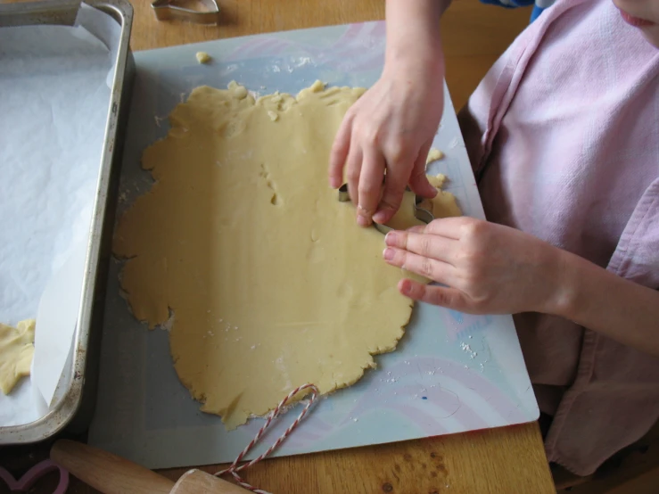 a person that is kneading food on a table