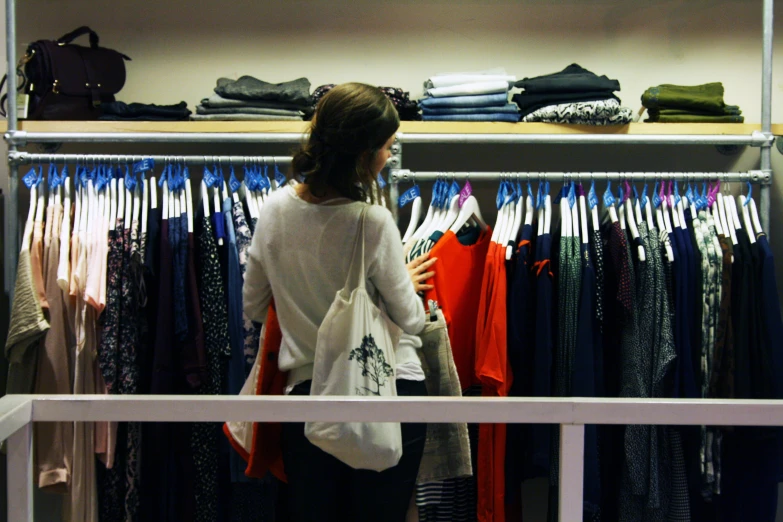 a woman is selecting clothing at the store