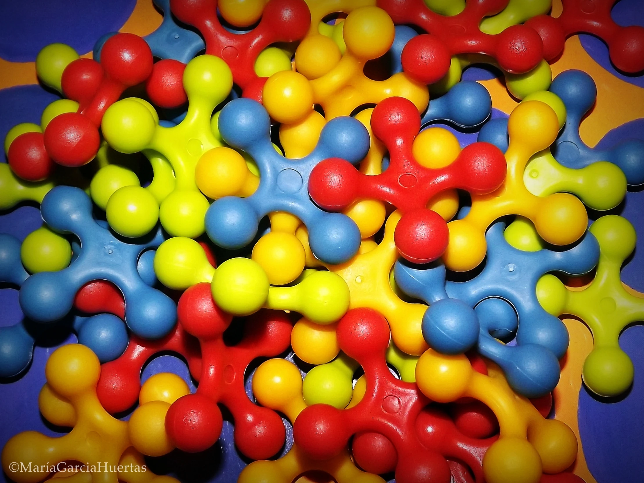 colorful, plastic balls arranged in a cluster on top of a purple plate