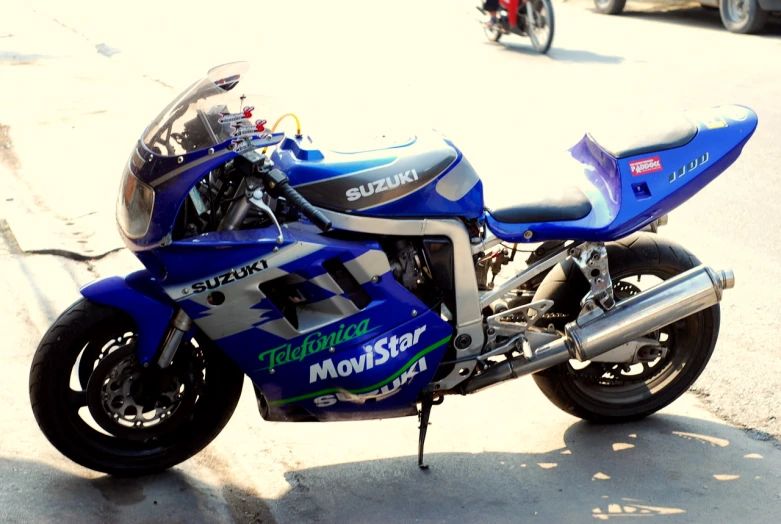 a blue and white motorcycle parked in the middle of a street