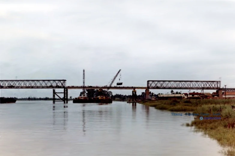 a bridge that is over water and there is grass below