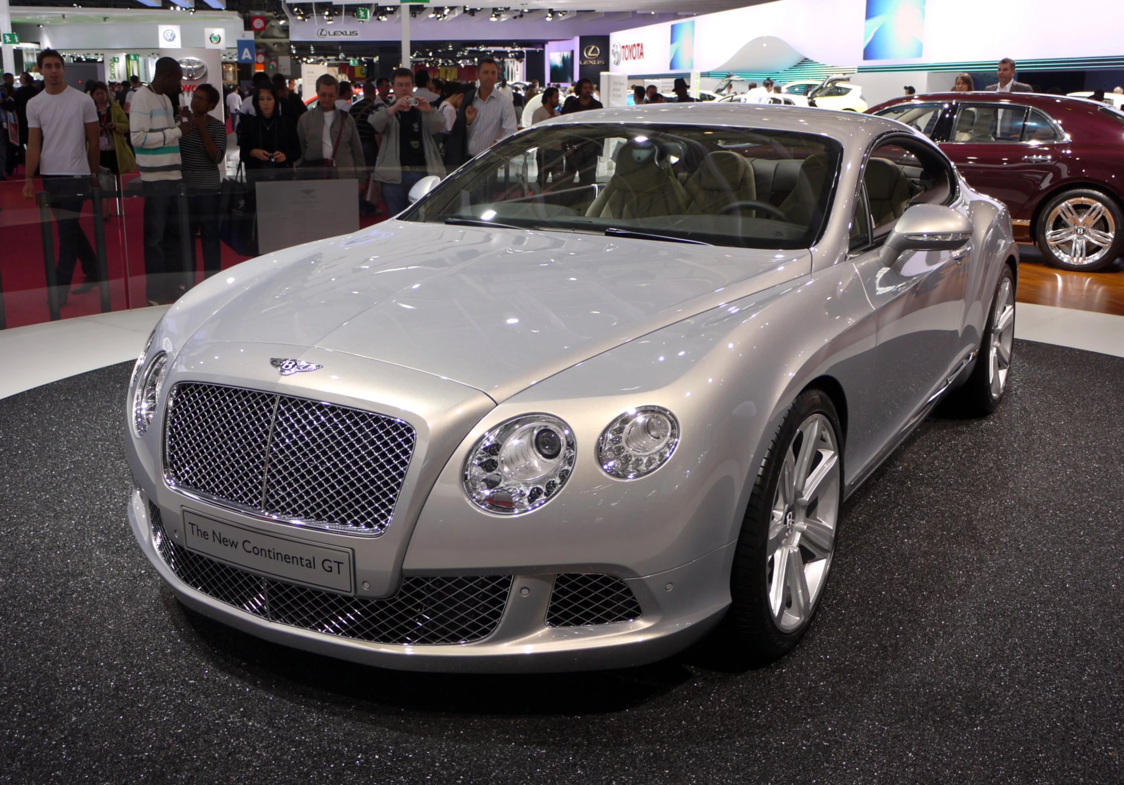 a silver car with chrome rims at a show