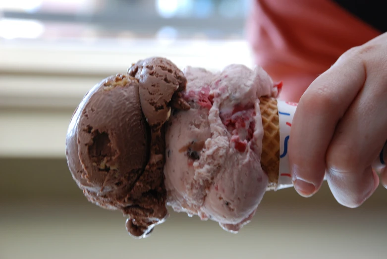 a person is holding an ice cream cone