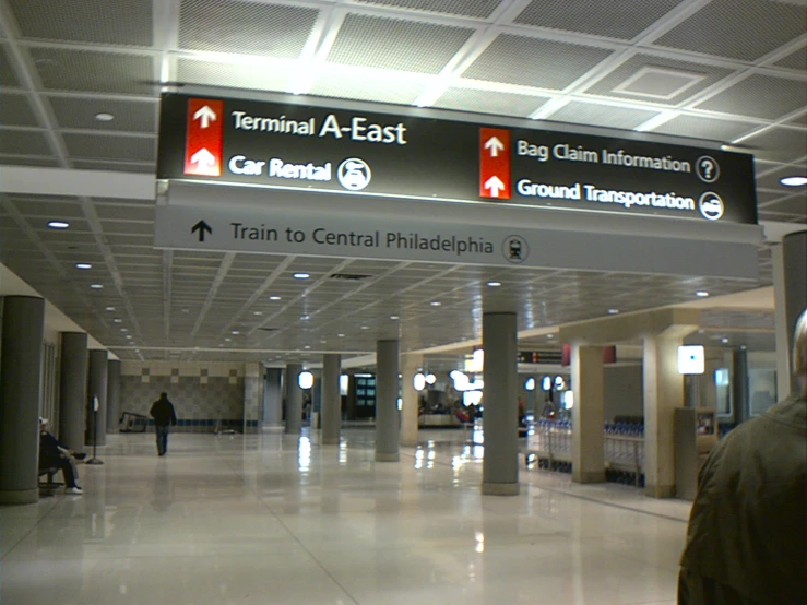 a man is standing under a sign for terminals