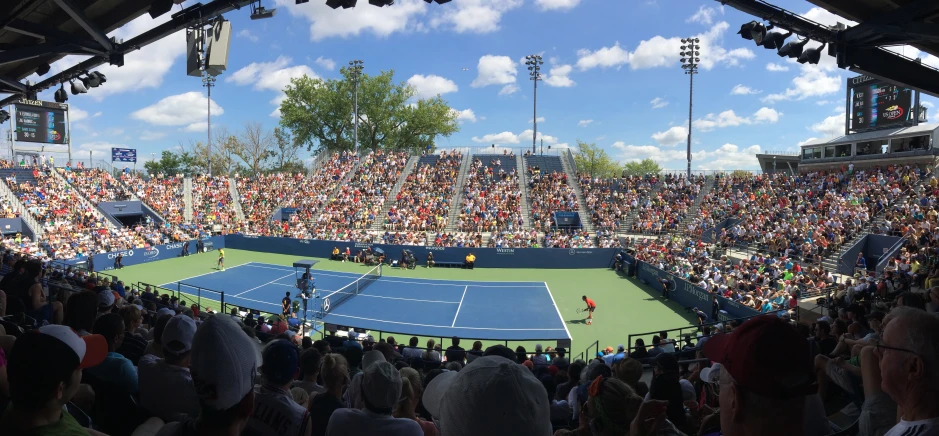 the audience at the tennis match watches the serve