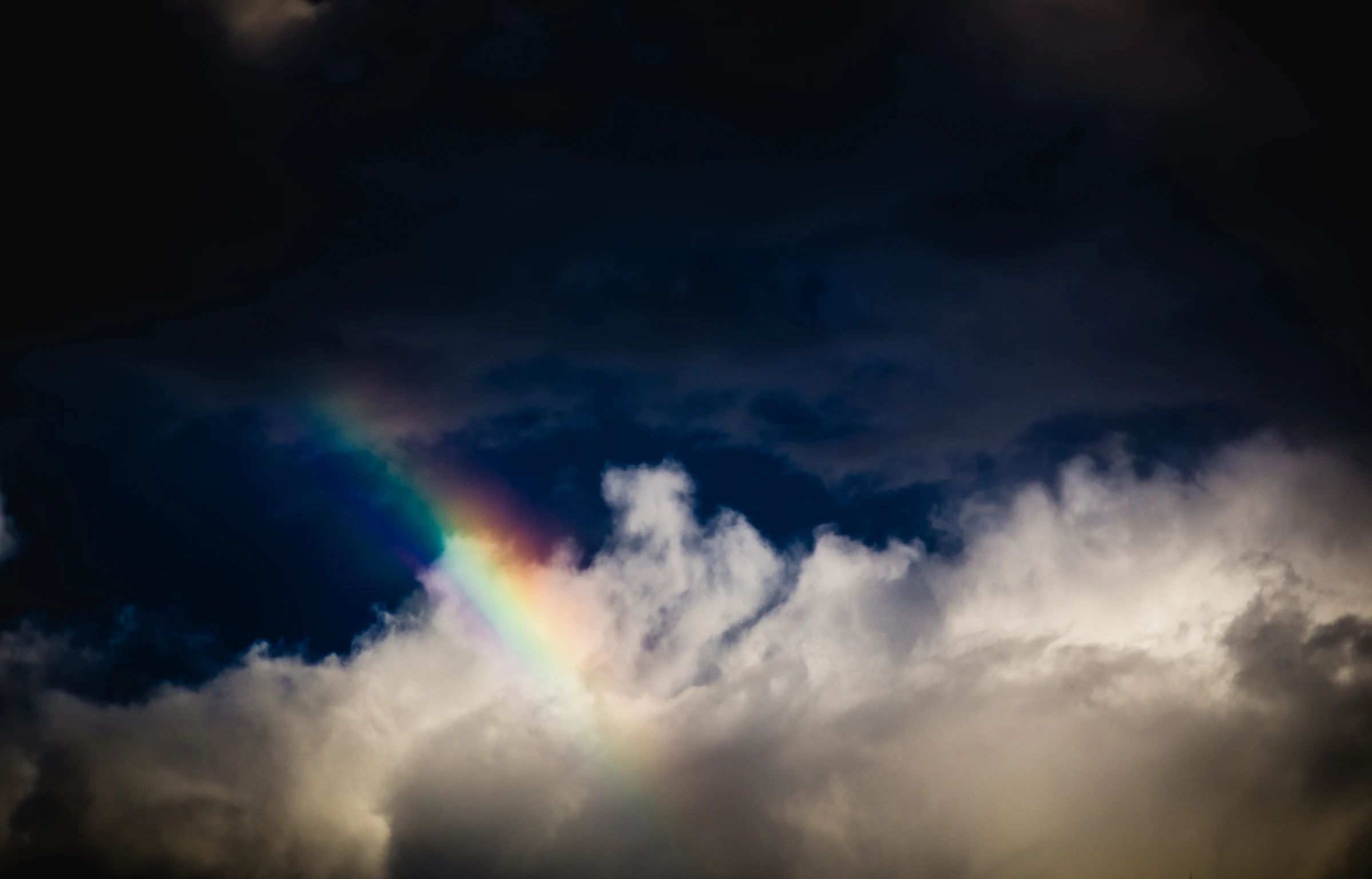 a colorful rainbow in a dark, cloudy sky