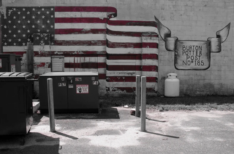 an american flag is being displayed in front of a mural