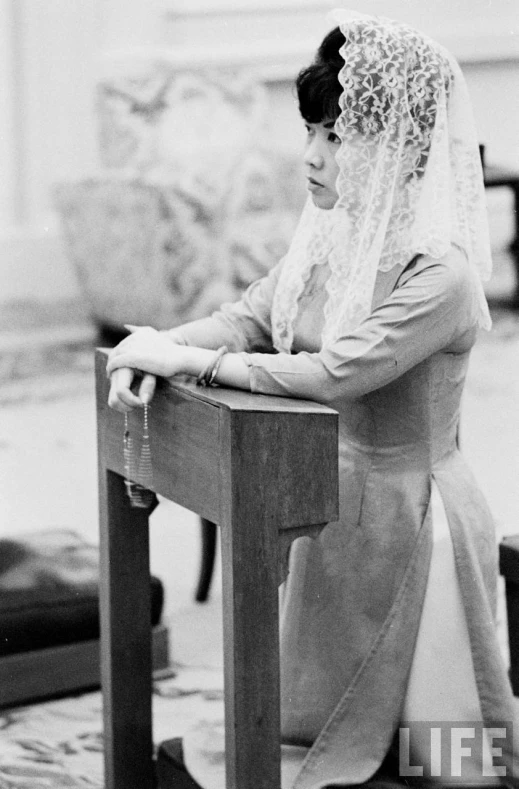 an old po of a woman in a wedding dress sitting on a chair