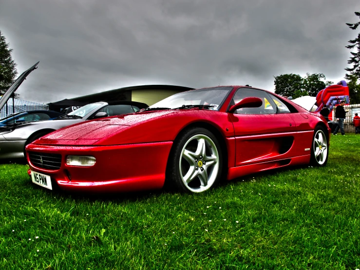 a bright red sports car parked in a grass field