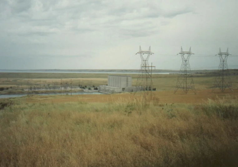 some power lines and power towers in a grassy field