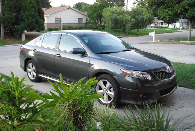 a dark colored car is parked on the sidewalk