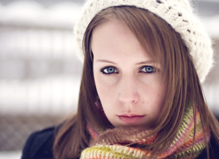 a pretty young lady with blue eyes wearing a hat