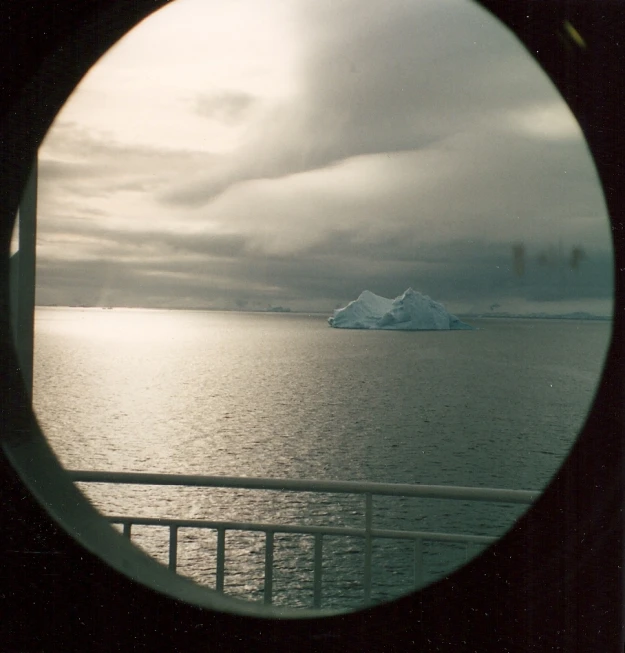 a po looking out at a large iceberg and water