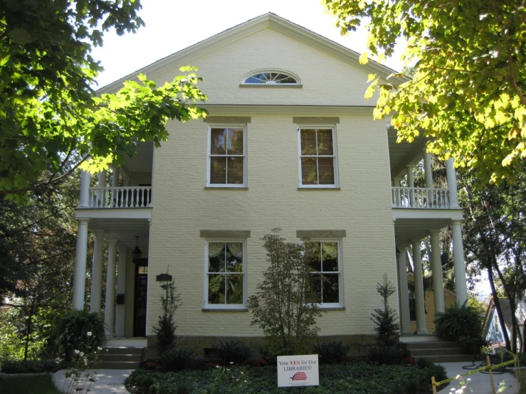 a house with several bushes and trees next to it