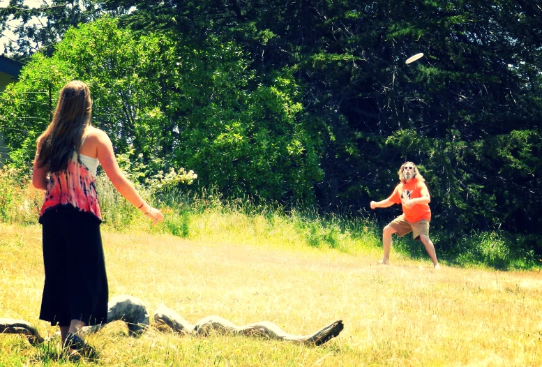 two girls playing frisbee in an open field