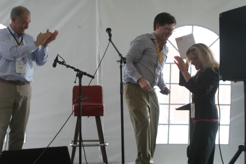 a man standing next to a woman as they hold microphones