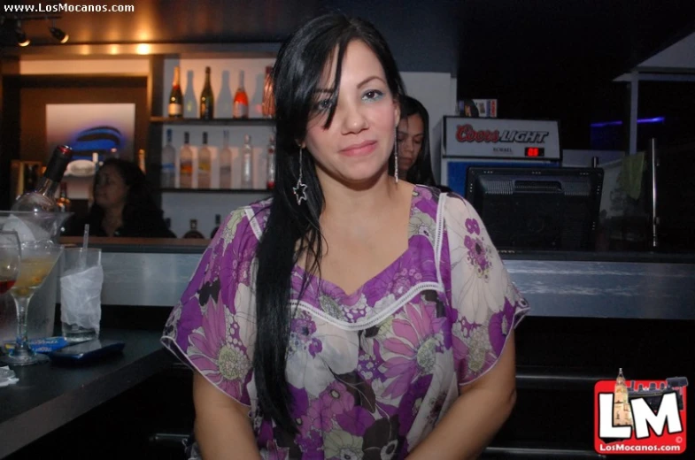 a woman sits in a bar and smiles