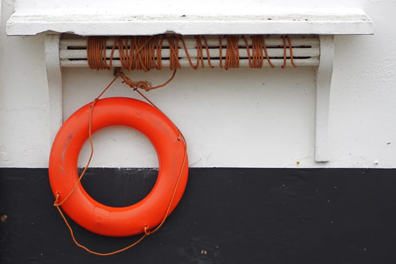 an orange life buoy hanging up against a wall