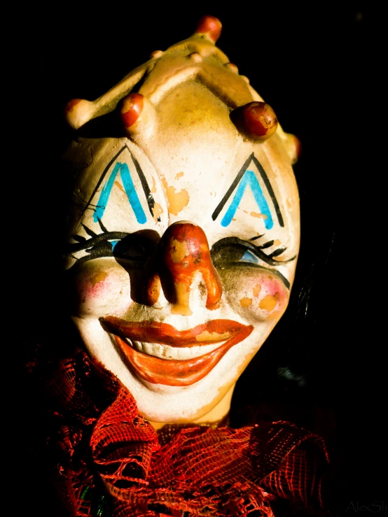 a clown with a red bow tie, mask, and hat