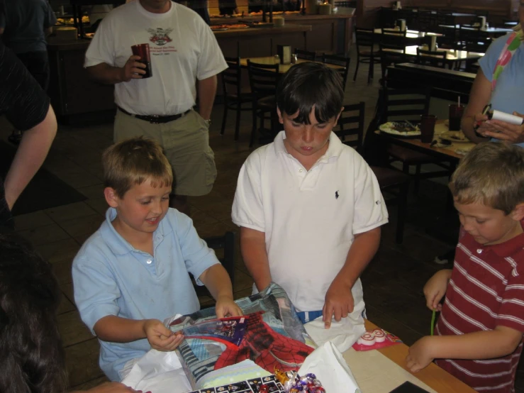 several children are at a table with cakes