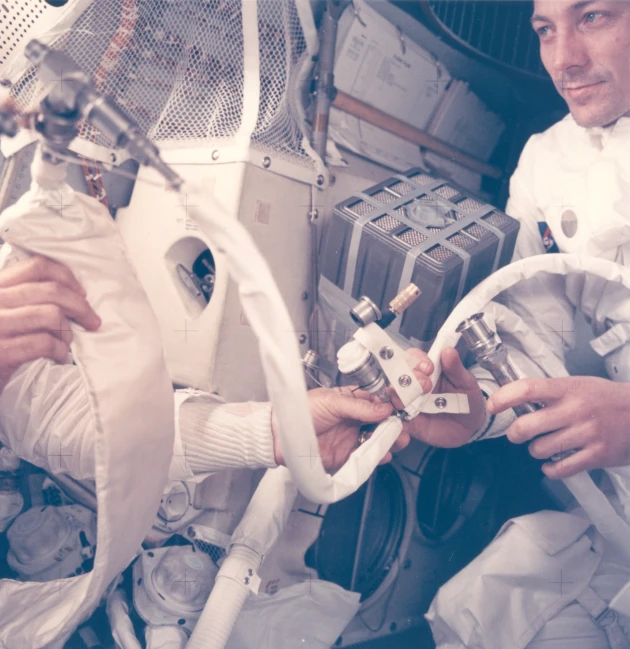 two men inside a space station looking at some wires