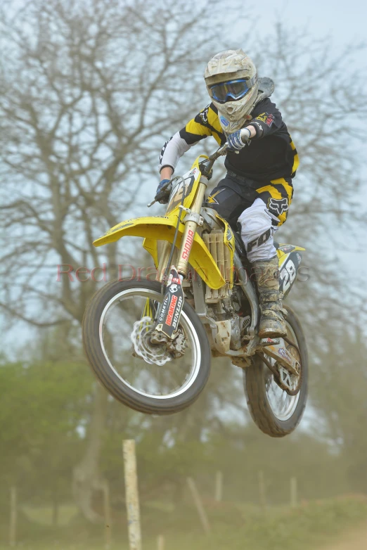 a person on a dirt bike does a jump over a forest