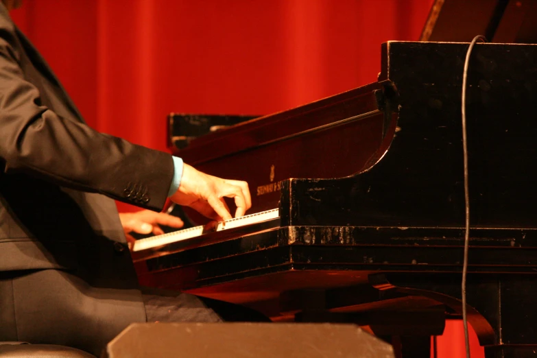 a man playing the piano in a red room