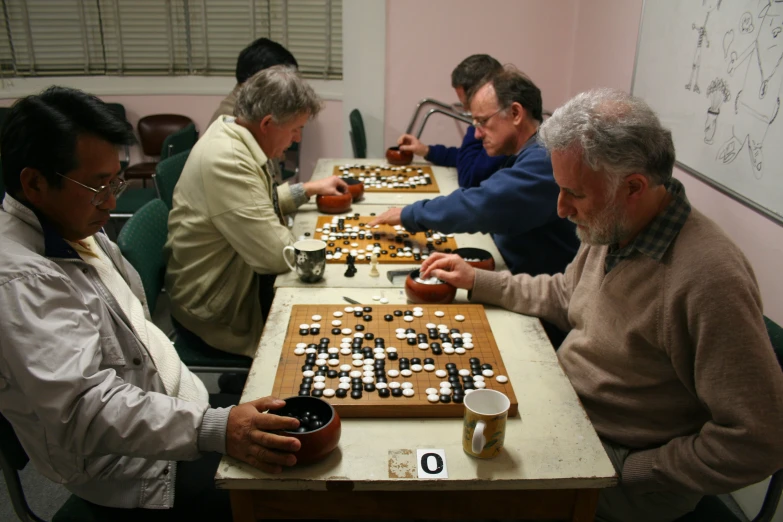 several men sitting around a table having a board game