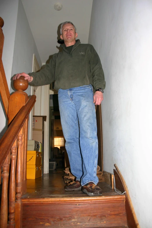 an older man stands on the stairs of a home