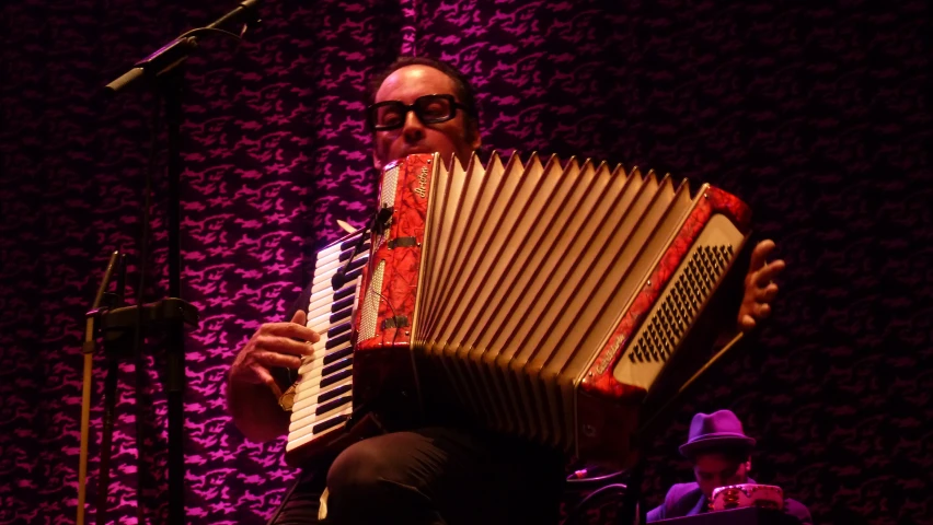 a man in black outfit playing an accordion