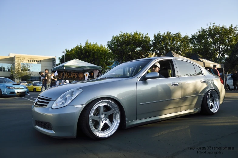 silver car in parking lot next to tables