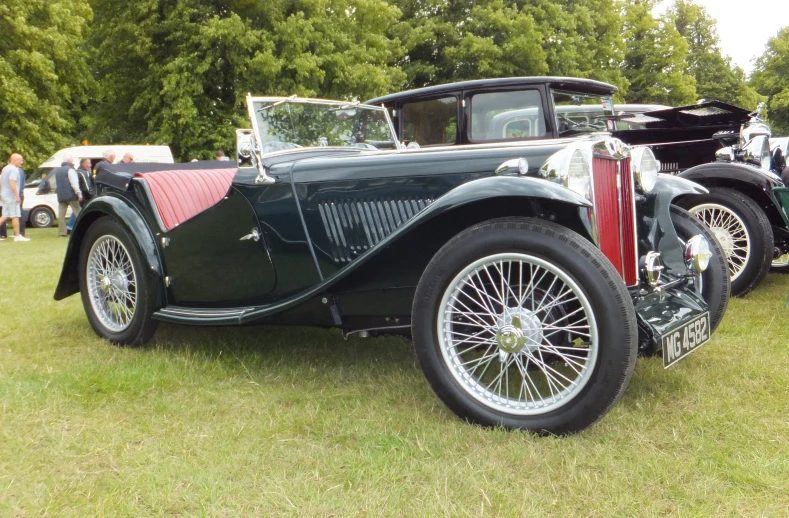 an old black model t is parked on grass