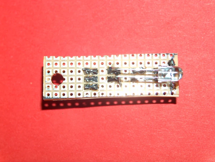 a printed circuit on top of a red surface